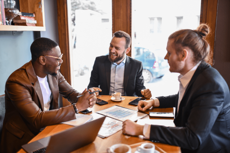3 business men seated around a table